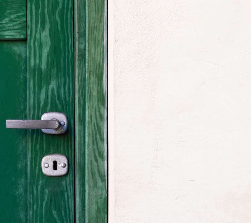 A green door against a white wall